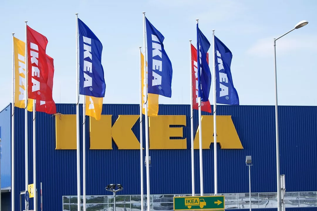 BRIGHT FLAGS ON POLES FLUTTER IN THE WIND OUTSIDE A BOX STORE