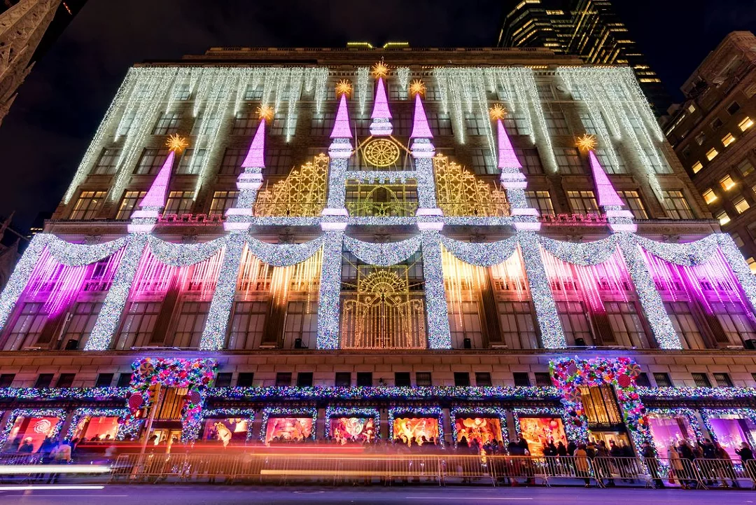 The front of Saks Fifth Avenue Department Store is decked with a Christmas light show and holiday season window displays.