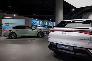 NEW CARS SIT ON A DEALERSHIP FLOOR, ONE BEARING A BYD LOGO