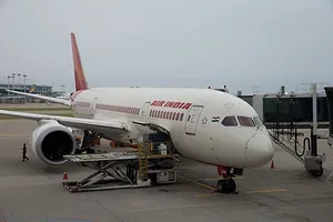 AN AIR INDIA PLANE SITS ON THE TARMAC OF AN AIRPORT