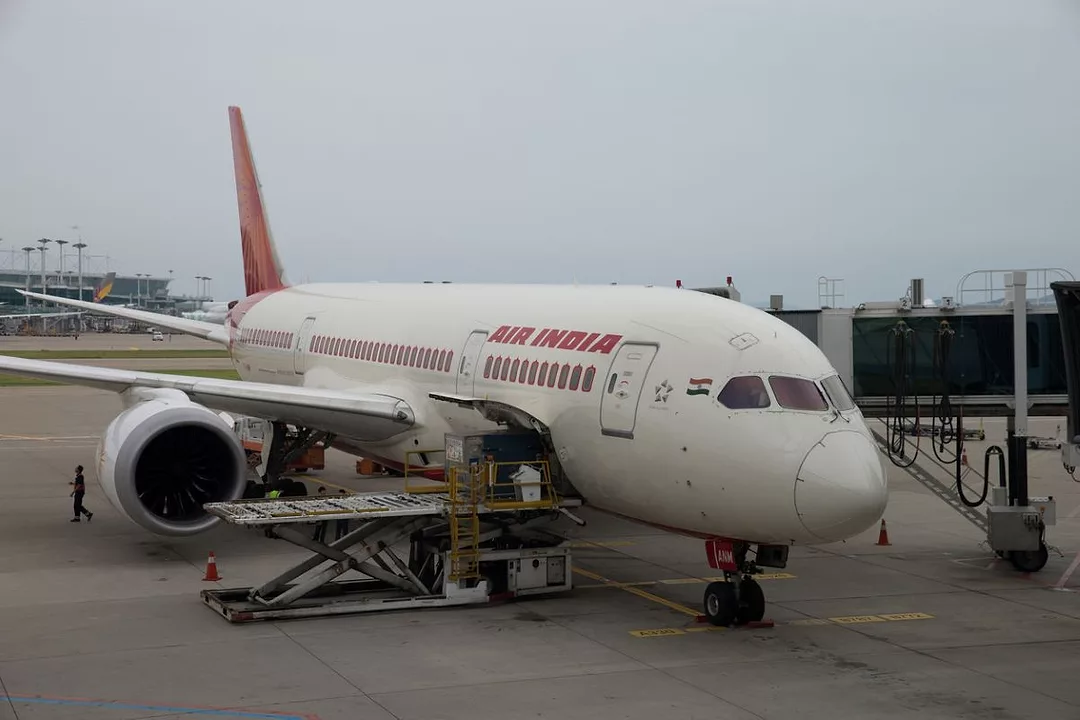 AN AIR INDIA PLANE SITS ON THE TARMAC OF AN AIRPORT