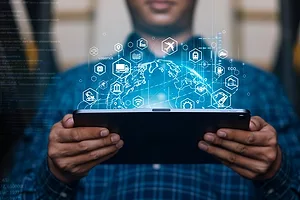 A MAN HOLDS UP A TABLET COMPUTER COVERED IN FREIGHT-RELATED GRAPHICS