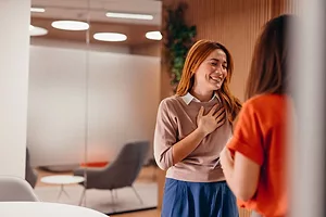 Grateful businesswoman thanking her colleague for good news in the office