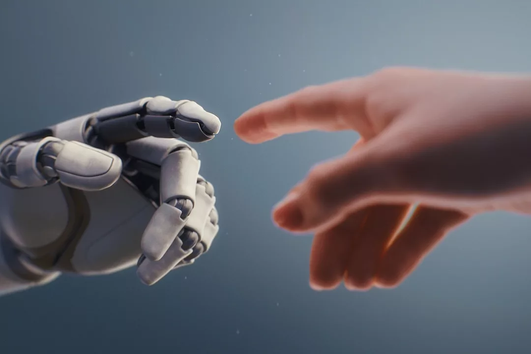 A human hand reaching out to a white robotic hand