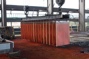 A CRANE LIFTS A HUGE BLOCK OF COPPER