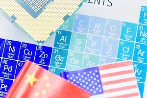 A MONTAGE OF LUMPS OF MINERALS ON TOP OF THE FLAGS OF THE US AND CHINA