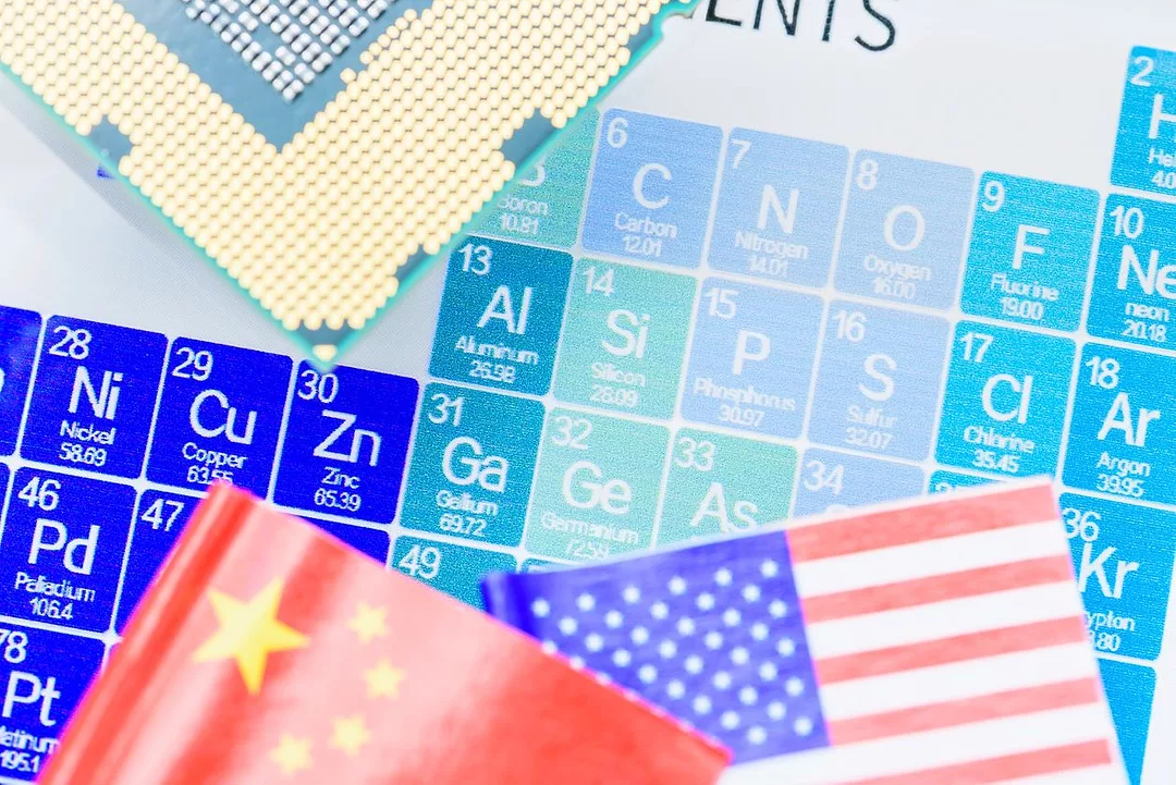 A MONTAGE OF LUMPS OF MINERALS ON TOP OF THE FLAGS OF THE US AND CHINA