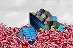 tariffs-supply-chain-iStock-2210403435.jpg A blue container ship stacked with multi-colored containers sinking into an ocean of red tape that reads "tariffs"