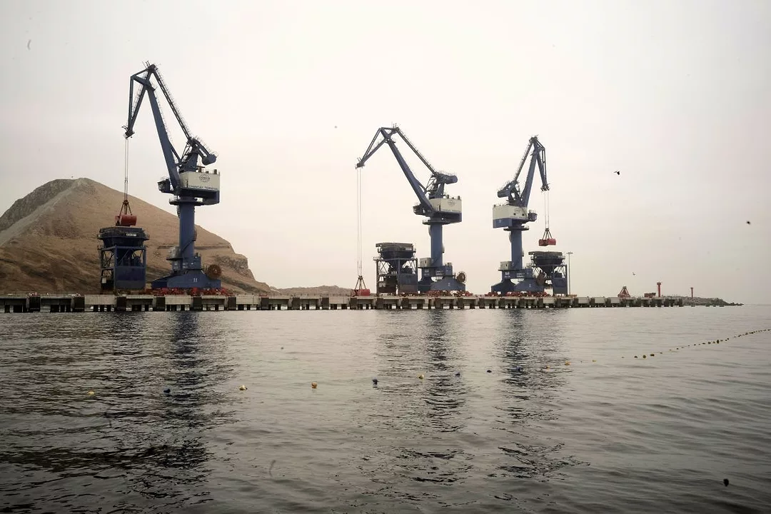 A VIEW ACROSS THE WATER AT A DOCK WITH CRANES