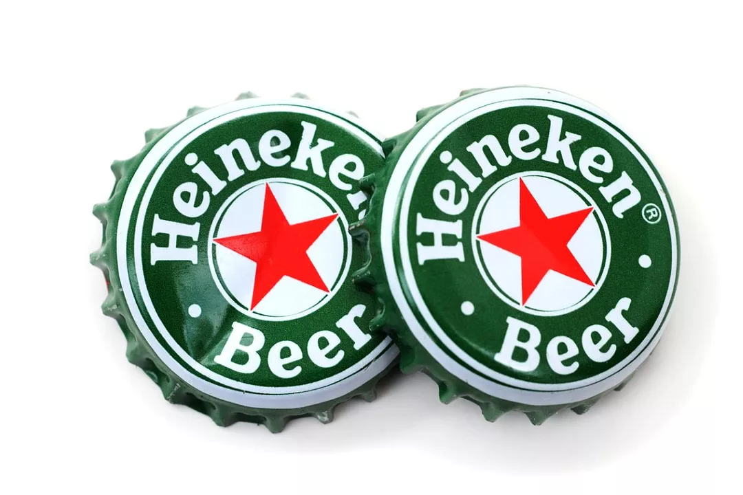 Heineken Beer Bottlecaps sit side by side on a white background