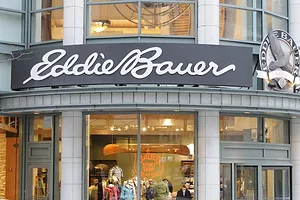 The front window of a storefront that reads "Eddie Bauer" in white cursive lettering across the top