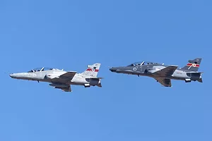 TWO GREY FIGHTER PLANES IN FLIGHT AGAINST A BLUE SKY