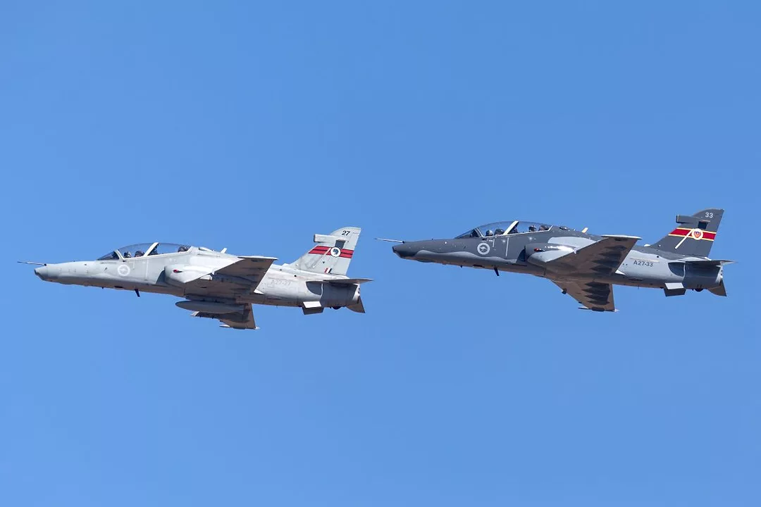 TWO GREY FIGHTER PLANES IN FLIGHT AGAINST A BLUE SKY