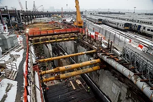 A GIANT CONSTRUCTION HOLE IN THE GROUND WITH PIPES AND METAL STRUCTURES