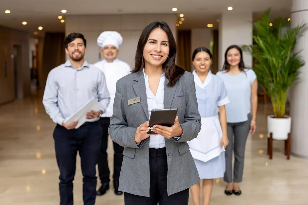 A Hotel manager leads a group of employees at a hotel lobby