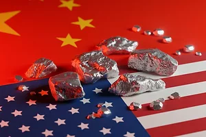 Mineral deposits sitting on top of the Chinese and American flags on a flat surface