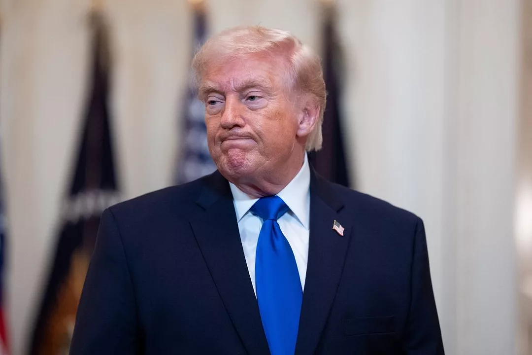 A MAN IN A JACKET AND BLUE TIE MAKES AN UNHAPPY FACE