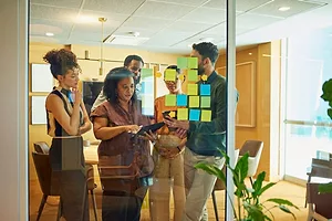 A diverse group of colleagues brainstorming ideas in modern office space.