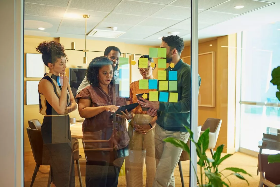 A diverse group of colleagues brainstorming ideas in modern office space.