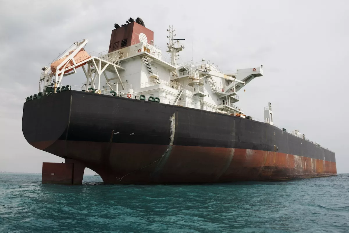 A large black and red container ship at sea