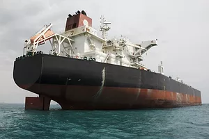 A large black and red container ship at sea