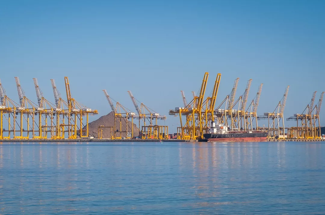 A PANORAMIC SHOT OF A PORT AT SEA WITH MANY YELLOW CRANES