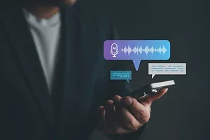 A BLURRED HUMAN FIGURE HOLDS UP A DEVICE WHICH IS SURROUNDED BY IMAGES OF AUDIO OUTPUT