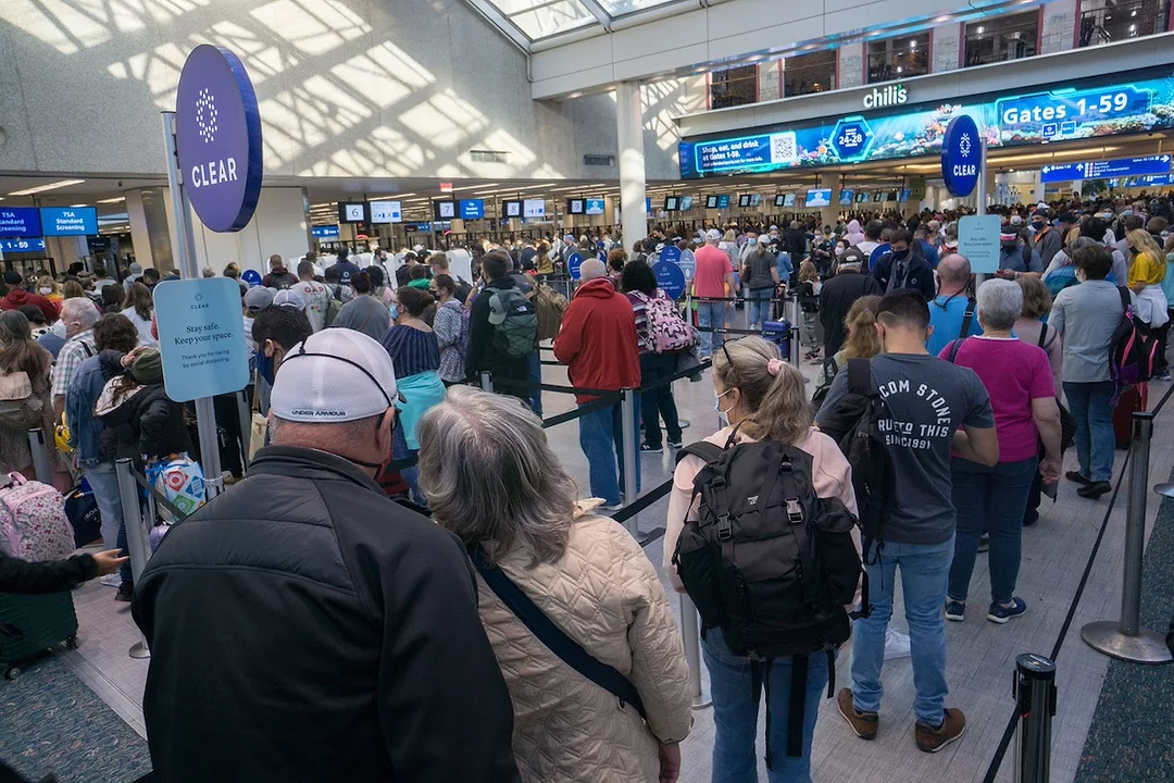 A crowd of people in line at an airport security terminal