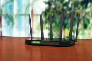 A BLACK BOX WITH MULTIPLE ANTENNAE AND GLOWING LIGHTS SITS ON A TABLE TOP