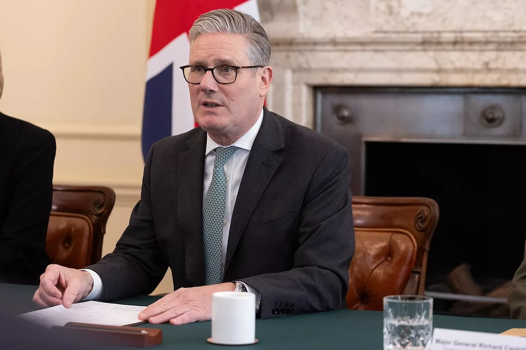 U.K. Prime Minister Keir Starmer sitting at a desk while wearing a black suit and green tie