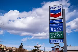 A blue Chevron gas station sign depicting gas prices over $5 a gallon
