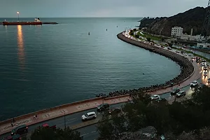 A LARGE SHIP IN THE DISTANCE PASSES A PORT 
