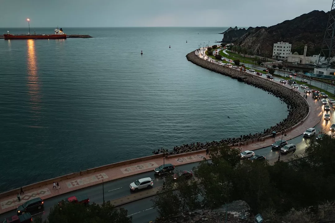 A LARGE SHIP IN THE DISTANCE PASSES A PORT