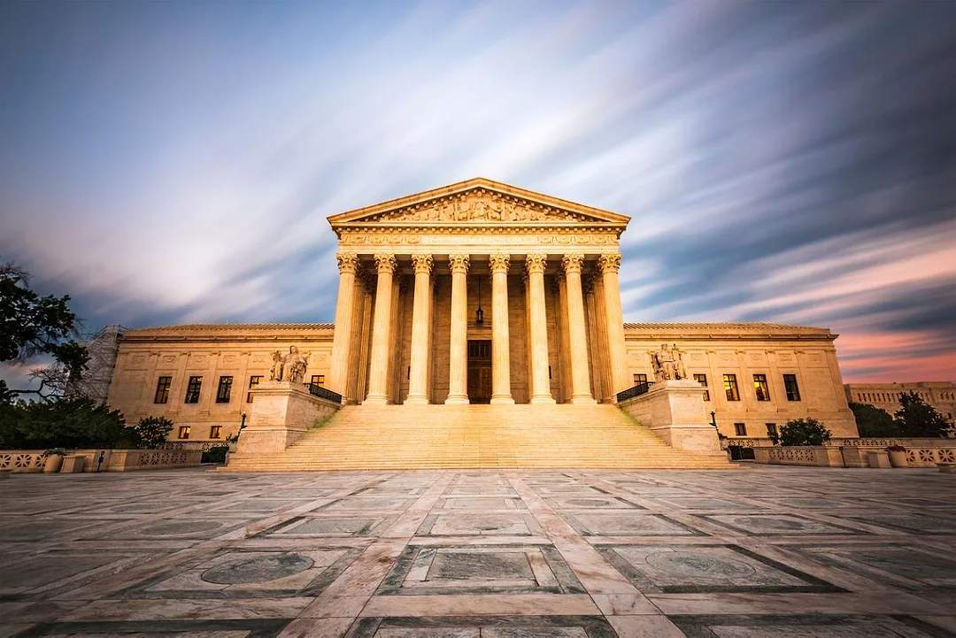 A GRAND NEOCLASSICAL BUILDING OF MARBLE WITH MULTIPLE COLUMNS STANDS ABOVE A MARBLE CAUSEWAY