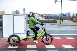 A bicycle courier delivering parcels in the city on a cargo bike