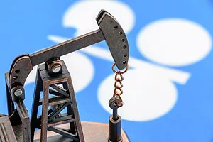 Oil pump jack and flag of OPEC or Organization of Oil Exporting Countries
