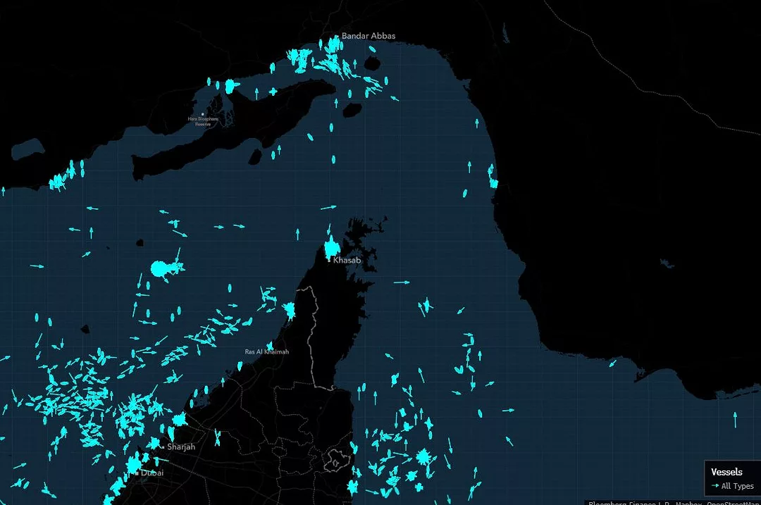 A MAP OF THE STRAIT OF HORMUZ IN BLACK SHOWS MANY BRIGHT BLUE DOTS REPRESENTING SHIPS