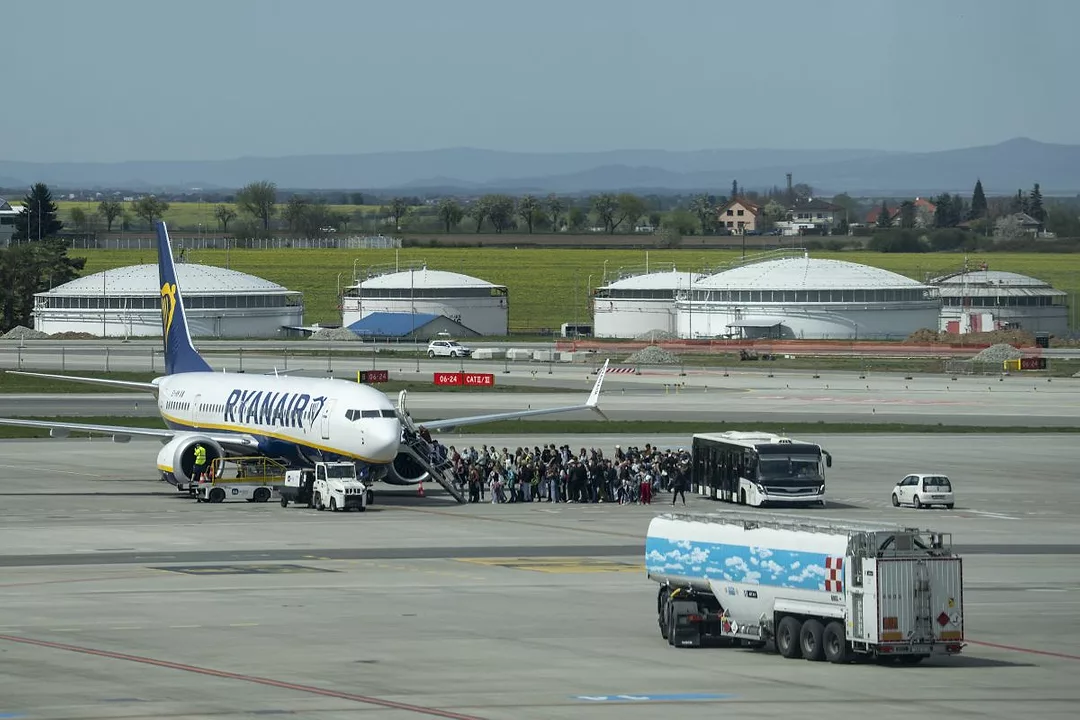 PASSENGERS MOUNT THE STEPS FROM AIRPORT TARMAC INTO A RYANAIR JET