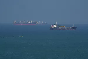A pair of black container ships at sea