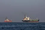 TWO COMMERICAL SHIPS AT SEA UNDER A DARK SKY