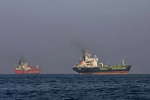 TWO COMMERICAL SHIPS AT SEA UNDER A DARK SKY