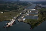 AN AERIAL VIEW OF A LARGE SHIP APPROACHING A LOCK SYSTEM ON A CANAL
