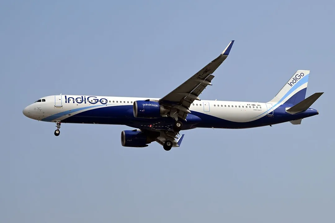 A plane bearing the IndiGo insignia flies through the sky