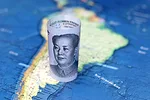 CHINA LATIN AMERICA YUAN LATAM iStock-Oleg Elkov-1379988615.jpg A banknote of Chinese yuan is rolled up sitting on the map of South America