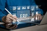 Photo of Businessman using tablet and laptop, overlaid with various icons and ERP