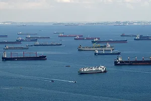 A group of container ships at sea, sitting in the Strait of Malacca