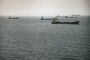 A group of container ships at sea on a cloudy day