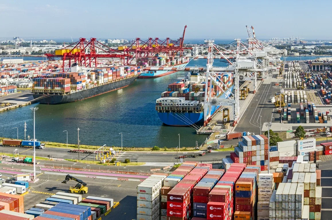 MULTIPLE SHIPS ARE DOCKED AT A BUSY CONTAINER PORT