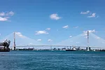 A SINGLE ARCH SUSPENSION BRIDGE SPANS A WIDE WATERWAY