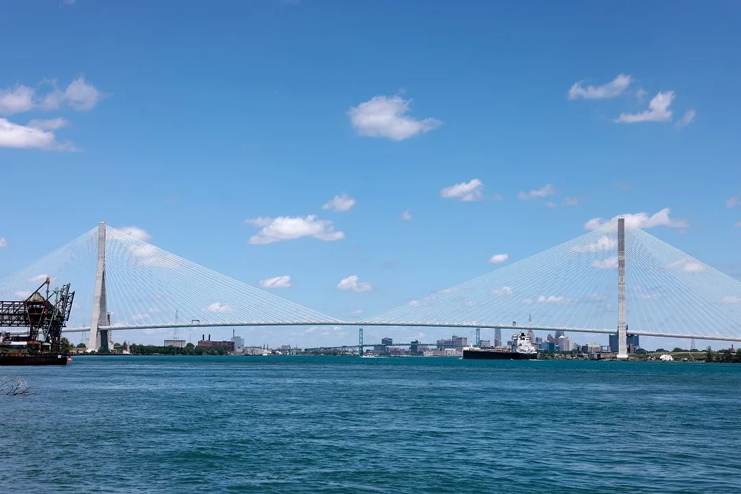 A SINGLE ARCH SUSPENSION BRIDGE SPANS A WIDE WATERWAY
